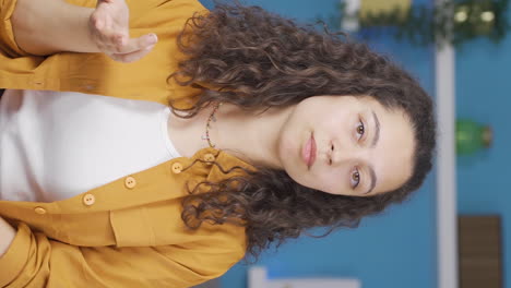 Vertical-video-of-Young-woman-looking-at-camera-with-dull-expression.